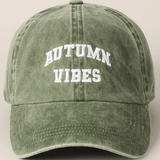 Green cap with 'AUTUMN VIBES' text on a beige background