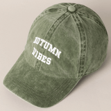 Green cap with 'AUTUMN VIBES' text on a beige background